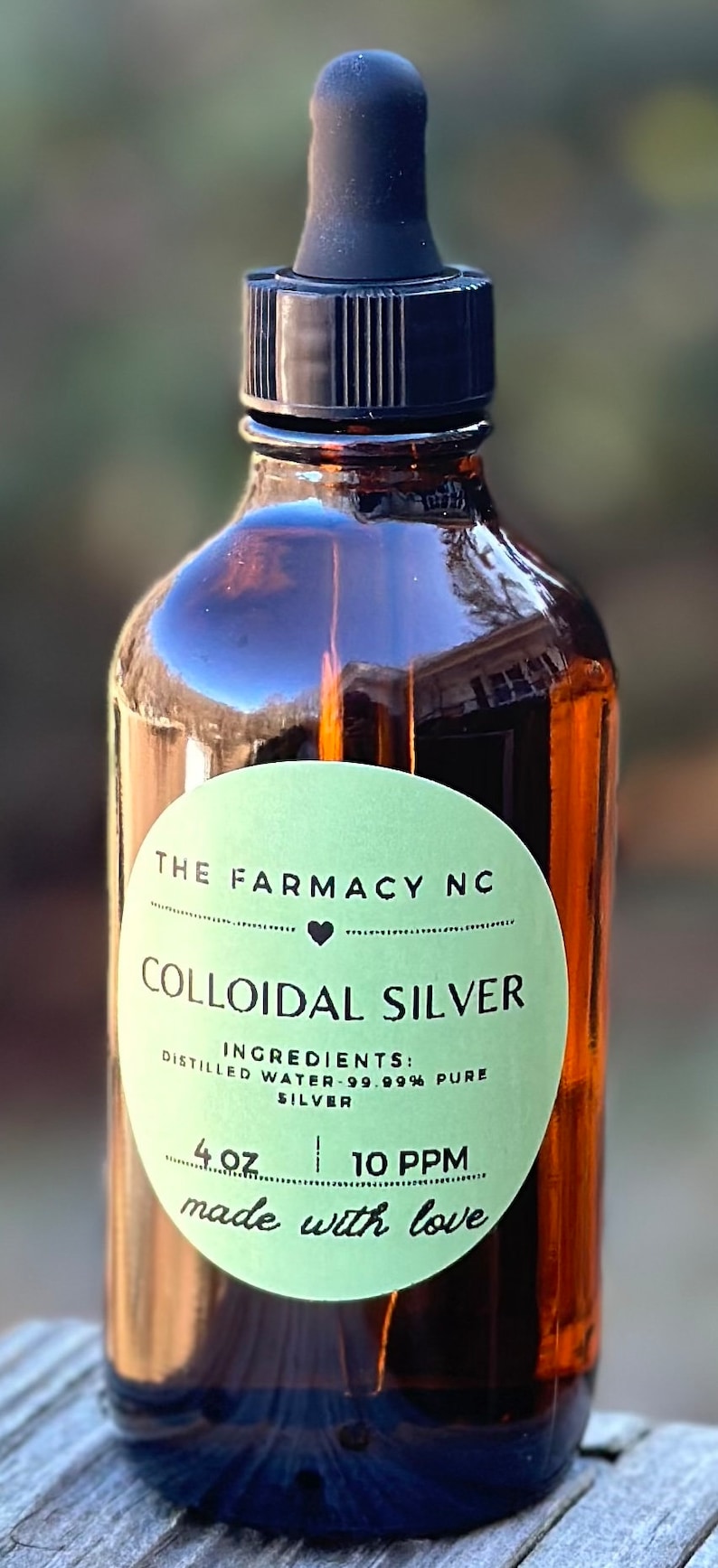 Puede incluir: Una botella de 118 ml de plata coloidal con un gotero. La etiqueta es verde y dice "The Farmacy NC" y "Colloidal Silver". Los ingredientes se enumeran como "Agua destilada - 99,99% plata pura" y la concentraci&oacute;n es de 10 PPM. La etiqueta tambi&eacute;n dice "hecho con amor".