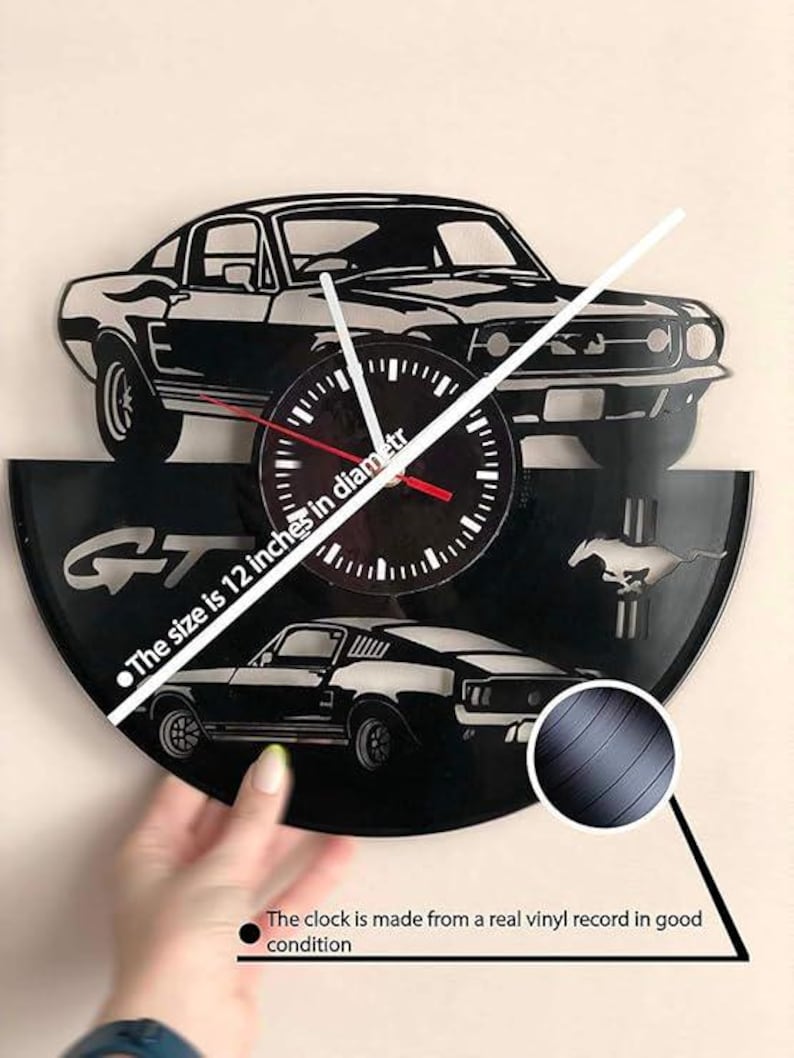 May include: A black vinyl record clock featuring a silhouette of a Ford Mustang GT. The clock is 12 inches in diameter and is made from a real vinyl record in good condition. "The size is 12 inches in diameter" and "The clock is made from a real vinyl record in good condition" are written below the clock.