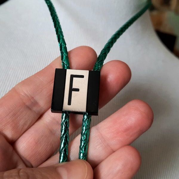 vintage F bolo tie, initial letter by Swank, silver and black on metallic green braided rope