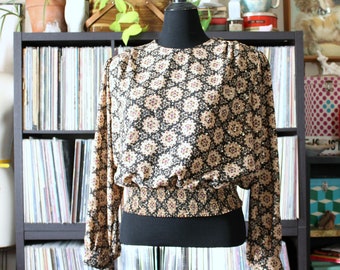 80s vintage smocked waist blouse, approx womens large xl, black metallic gold medallion print top with billowy sleeves, cropped fit