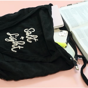 Faith-inspired corduroy tote bag with unique hand embroidery reading “Blessed,” stitched with care for Christian women who love stylish, meaningful accessories. Features a large front pocket, interior compartments, and a sturdy zipper closure. Perfect for Bible study, church, or daily errands. This handmade tote makes an uplifting gift for friends, sisters, or ministry leaders who embody faith and grace.
