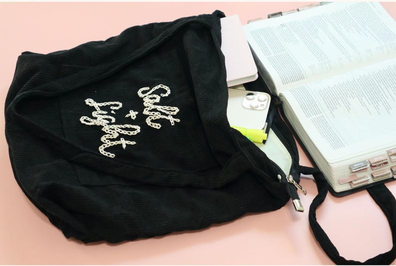 Faith-inspired corduroy tote bag with unique hand embroidery reading “Blessed,” stitched with care for Christian women who love stylish, meaningful accessories. Features a large front pocket, interior compartments, and a sturdy zipper closure. Perfect for Bible study, church, or daily errands. This handmade tote makes an uplifting gift for friends, sisters, or ministry leaders who embody faith and grace.