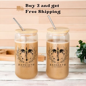 May include: Two clear glass tumblers with bamboo lids and stainless steel straws. Each tumbler features a black and white graphic of a dragon with a celestial design and the text "Basgiath War College".