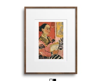 May include: Framed art print featuring a woman in a pink and black striped dress, holding a book. The artwork has a red and yellow background. The frame is a dark brown color. The print is from Quadro Gallery.