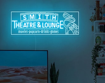 May include: A blue neon sign with white text that reads "SMITH THEATRE & LOUNGE" and "movies-popcorn-drinks-games". The sign is lit up and has a film reel design.