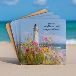 May include: Four square coasters with a coastal painting of a lighthouse, wildflowers, and ocean. The coasters have a light blue background with the text "Waves, wildflowers, and whispered dreams."