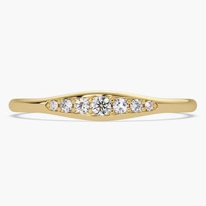 May include: A delicate gold band ring with a row of small diamonds set in a curved design.