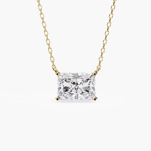 May include: A gold chain necklace with a large, clear, square-shaped diamond pendant.