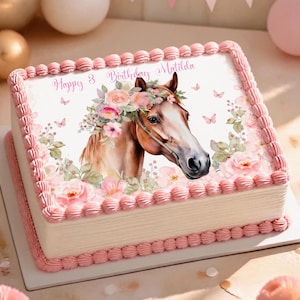 May include: A rectangular cake with white frosting and pink piped borders. The top features an edible image of a brown horse wearing a floral crown, surrounded by pink flowers and butterflies, with the text Happy 8 Birthday Matilda.