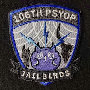 May include: A black and blue embroidered patch with a white spiderweb design and a purple owl with a lightning bolt behind it. The text "106TH PSYOP" is at the top and "JAILBIRDS" is at the bottom.