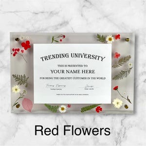 Puede incluir: Un marco acr&iacute;lico transparente con un certificado que dice "TRENDING UNIVERSITY" y "YOUR NAME HERE". El marco est&aacute; decorado con flores y vegetaci&oacute;n secas rojas, blancas y amarillas. El texto "Red Flowers" est&aacute; en la parte inferior.
