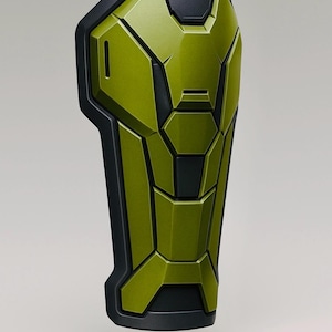 May include: A green and black segmented armor piece. The item has a geometric design with a metallic finish. The edges and some segments are black, while the main body is a vibrant green.