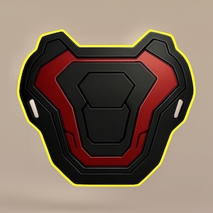 May include: A black and red shield-shaped object with a yellow outline. The shield has a geometric design with a central red triangle and a black outer frame. Two small, rectangular cutouts are on the sides.
