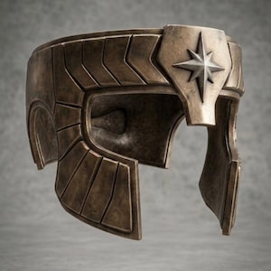 May include: A bronze-colored helmet featuring a weathered, metallic finish with a segmented panel design. The front center displays a prominent, raised silver-toned star emblem with eight sharp points, set against a smooth, shield-like plate.