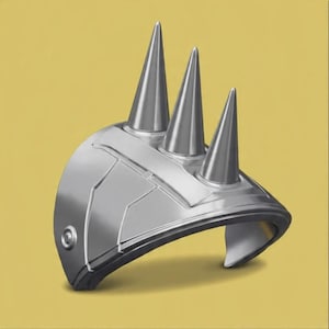 Puede incluir: Un casco plateado con tres puntas cónicas prominentes, sobre un fondo amarillo. El casco presenta un diseño curvo con paneles geométricos y un brillo metálico, evocando un estilo futurista.