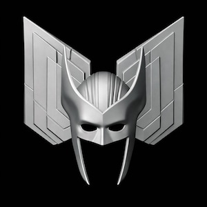 May include: A silver-colored mask with a stylized design, featuring a central face mask with eye openings and a pointed lower section. The mask is flanked by two large, geometric wing-like structures, all against a black background.