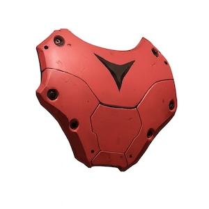 May include: A red, segmented shield with a black arrow-shaped design. The shield has a slightly weathered appearance, with visible screw heads and panel lines. The overall shape is curved and ergonomic, suggesting it is designed to be worn.