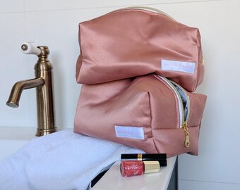 Gerecyclede, vintage-stijl, multifunctionele toilettas van oudroze satijn met een bloemenvoering.