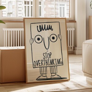 May include: A framed illustration of a person holding a sign that says "Stop Overthinking". The person has a simple cartoon face with two large eyes and a smile. The illustration is in black and white and is set against a light beige background.