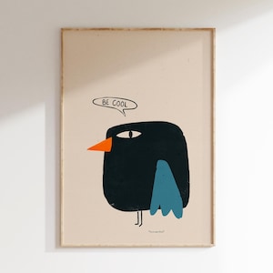 May include: A framed wall art print featuring a stylized black bird with a bright orange beak and blue wing on a light beige background. Above the bird is a speech bubble containing the text BE COOL. The bird has a single visible eye.