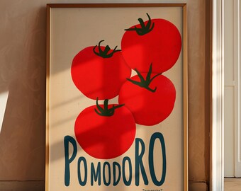 May include: A framed art print featuring four large red tomatoes with green stems against a cream background. The word "POMODORO" is written in blue script below the tomatoes. The print has a gold-colored frame.