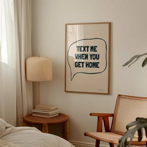 May include: A framed print with a beige background and a black speech bubble that says "Text me when you get home".