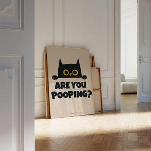 May include: A black cat with yellow eyes peeks over a white wall with the text "Are you pooping?" printed in black.