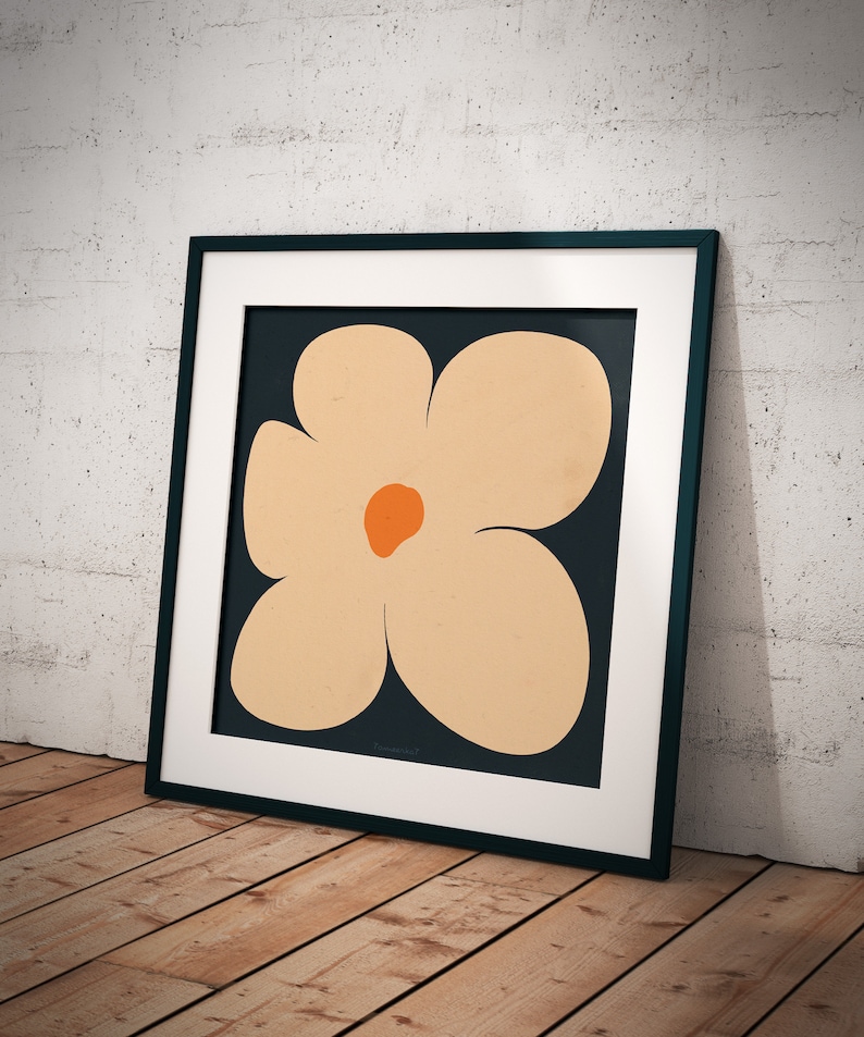May include: A framed print of a stylized flower with five petals. The flower is a light orange color with a dark orange center. The background is a dark blue color.