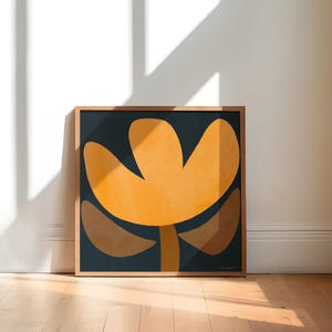 May include: A framed abstract art print featuring a stylized flower with a yellow center and brown petals on a dark blue background.