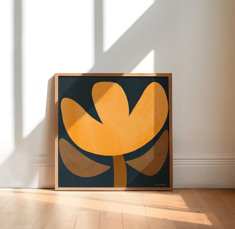 May include: A framed abstract art print featuring a stylized flower with a yellow center and brown petals on a dark blue background.