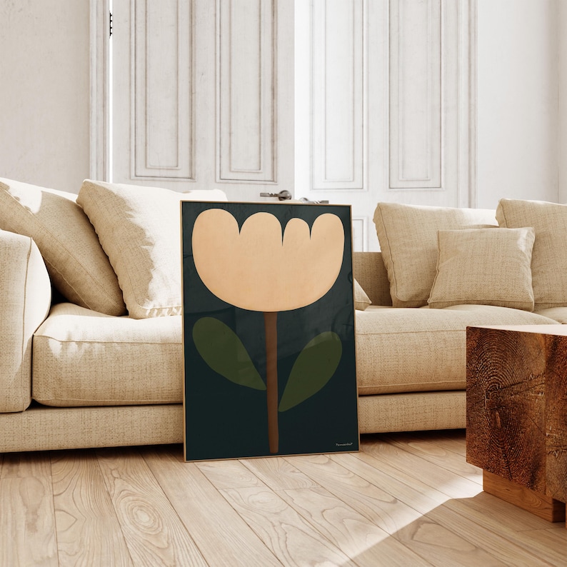 May include: A framed print of a stylized flower with a peach-colored blossom, green leaves, and a brown stem on a dark blue background.