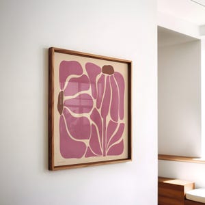 Pu&ograve; includere: Una stampa incorniciata di un design floreale astratto rosa. Il fiore &egrave; composto da diverse forme sovrapposte e si trova su uno sfondo crema.