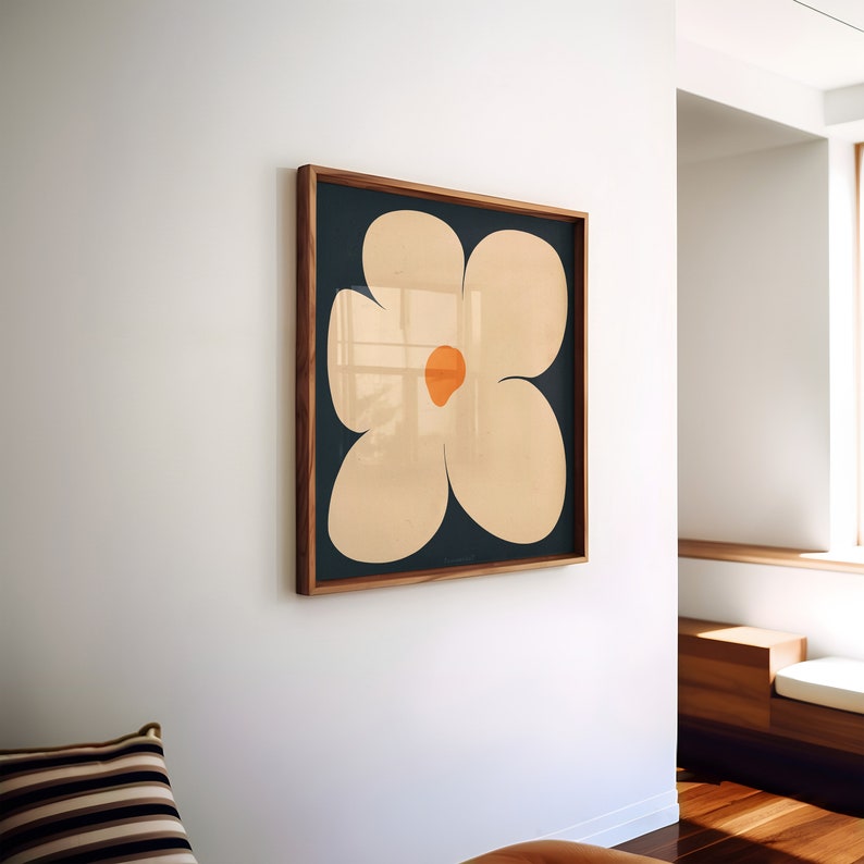 May include: A framed print of a stylized white flower with an orange center on a dark blue background.