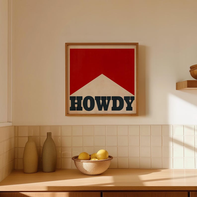 May include: A framed print with a red and white geometric design and the word "HOWDY" in black lettering.