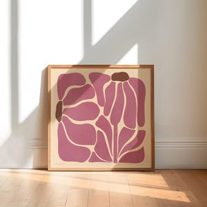 Pu&ograve; includere: Una stampa incorniciata di un design floreale astratto in rosa e marrone. La stampa raffigura due fiori stilizzati con petali arrotondati e uno stelo.