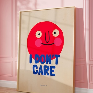 May include: A framed print with a red cartoon face and the text "I DON'T CARE" in blue letters. The artist's name "Tommeka?" is printed in smaller letters at the bottom.