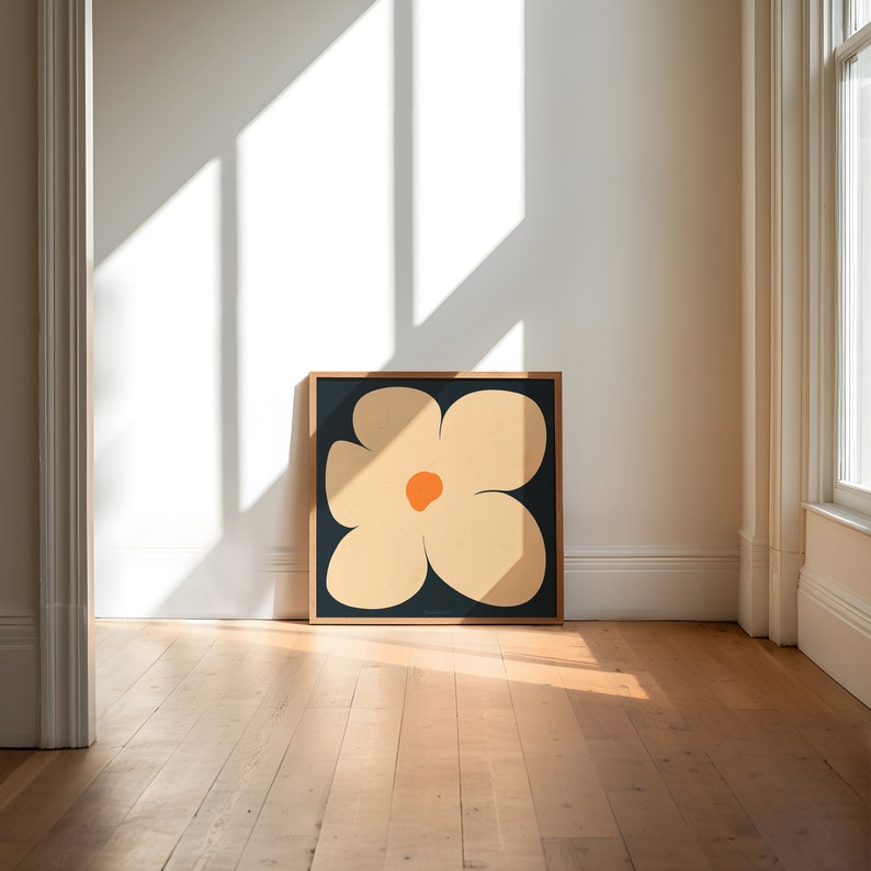 May include: A framed print of a stylized flower with five petals in shades of beige and orange on a dark blue background.
