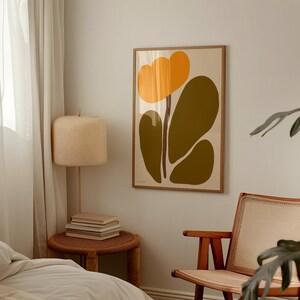 Peut inclure: Une impression d'art abstrait encadr&eacute;e avec une fleur jaune et des feuilles vertes sur un fond blanc.