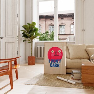 May include: A framed poster with a red circle and a smiling face. The text "I DON'T CARE" is written in blue letters below the circle.