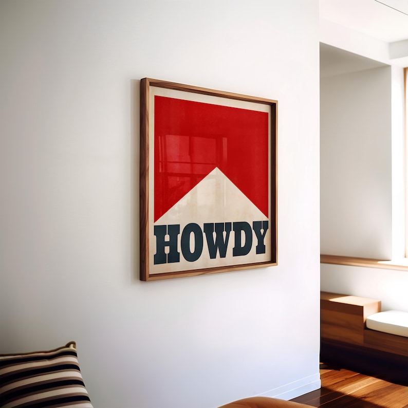 May include: A framed print with a red and white design. The design resembles a cigarette pack with the word "HOWDY" in black letters.