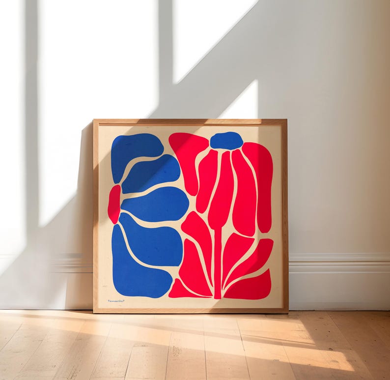 May include: A framed print of a stylized abstract floral design. The print features two large flowers, one in blue and one in red, against a cream background.