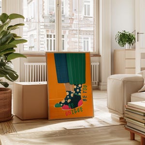 May include: A poster with a yellow background featuring a pair of legs wearing mismatched socks with polka dots and the text "Be You Be Unique".