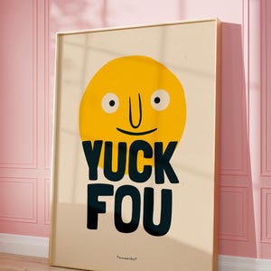 K&ouml;nnte beinhalten: Ein gelbes Cartoon-Gesicht mit einem breiten L&auml;cheln und dem Text "YUCK FOU" in schwarzen Buchstaben. Das Bild ist auf einem beigefarbenen Hintergrund mit einem goldenen Rahmen.