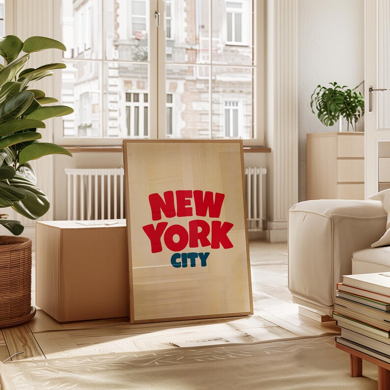 May include: A framed print with a light wood background and the text "NEW YORK CITY" in red and blue letters.
