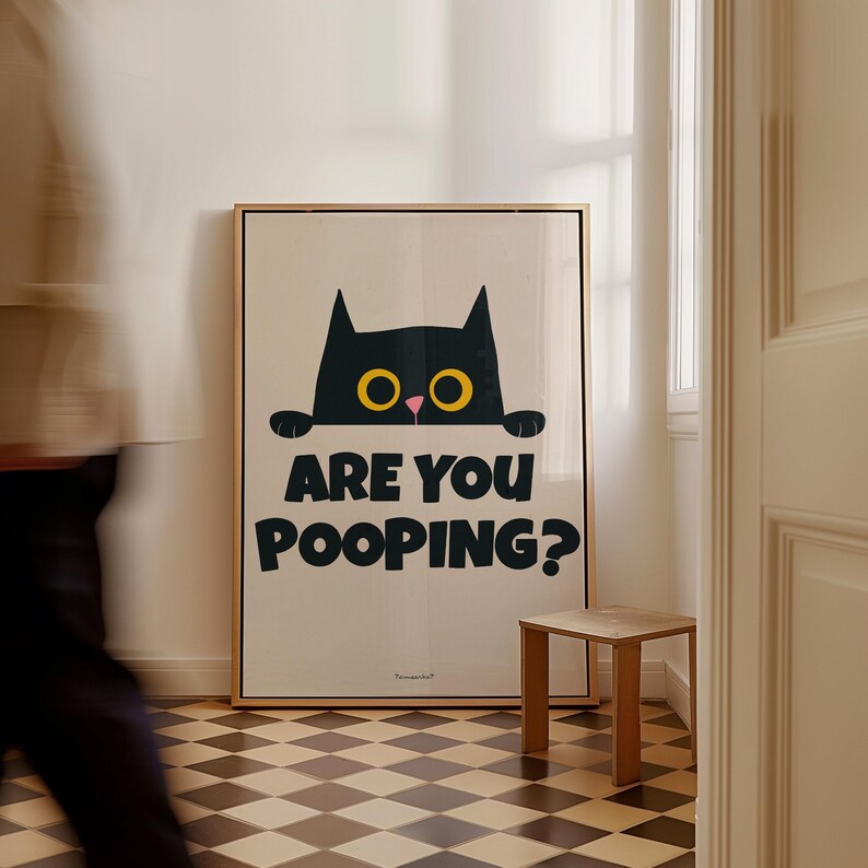 May include: A black cat with yellow eyes peeks over a wall with the text "Are you pooping?" printed below. The poster is framed in wood and hangs on a white wall.