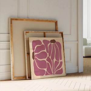 Pu&ograve; includere: Due stampe d'arte incorniciate, una sopra l'altra. La stampa superiore &egrave; un design floreale astratto rosa. La stampa inferiore &egrave; una tela bianca.