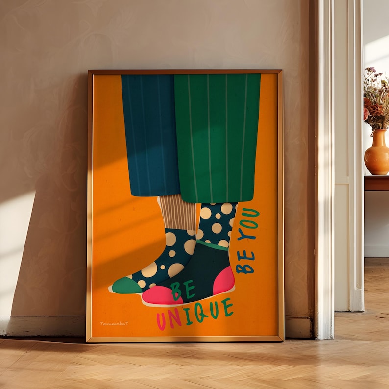 May include: A poster with an orange background featuring a pair of legs wearing colorful socks with polka dots. The text "Be Unique Be You" is written vertically on the right side of the poster.