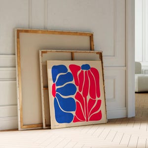 May include: A framed abstract art print featuring a blue and red floral design. The print is on a white background and is framed in a gold frame.