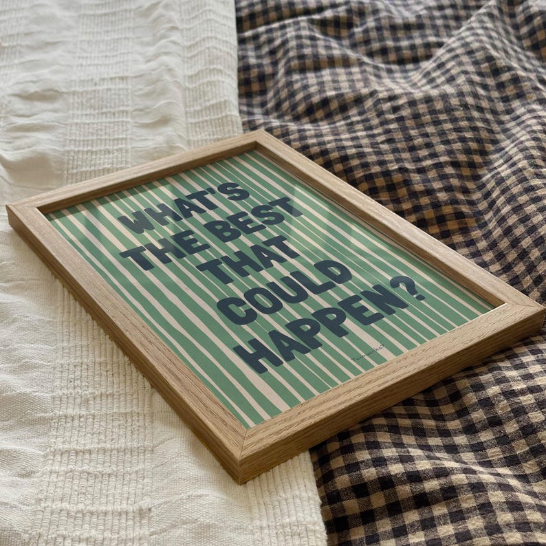 Puede incluir: Una impresi&oacute;n enmarcada con un fondo a rayas verde y blanco y el texto "What's the best that could happen?" en letras azul oscuro.