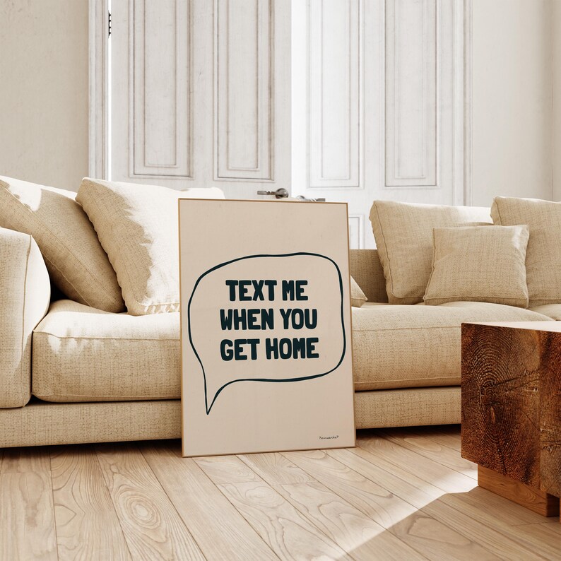 May include: A beige poster with a black speech bubble that says "Text me when you get home".